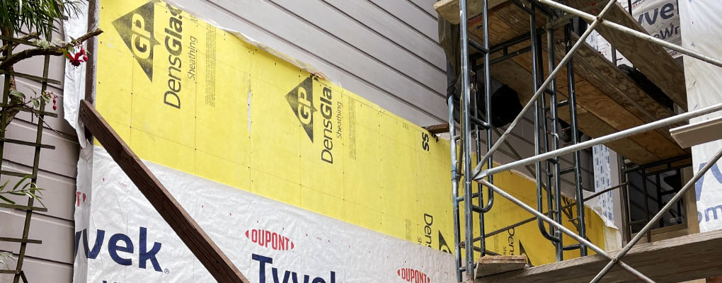 Matthew Kelly Construction is overseeing the building under construction, featuring scaffolding and walls clad in Tyvek and DensGlass sheathing panels.